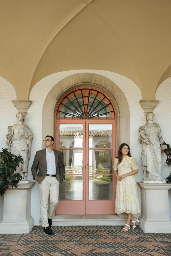 Couple framed by arched columns during their Villa Terrace engagement session in Milwaukee