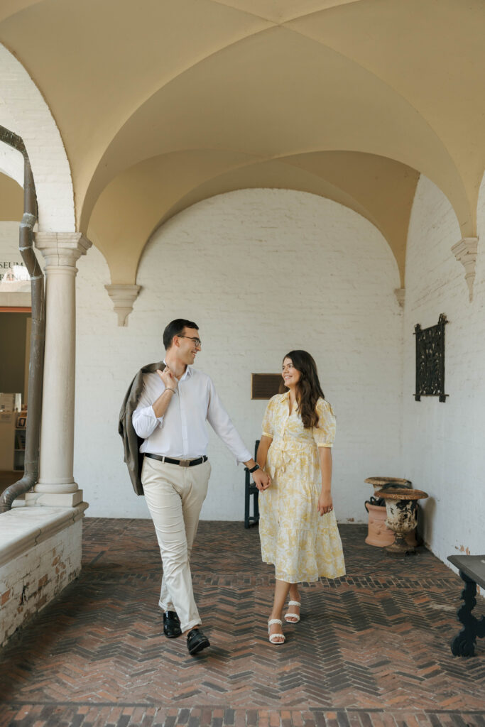 Couple sharing a candid moment under the archways at their Villa Terrace engagement session in Milwaukee