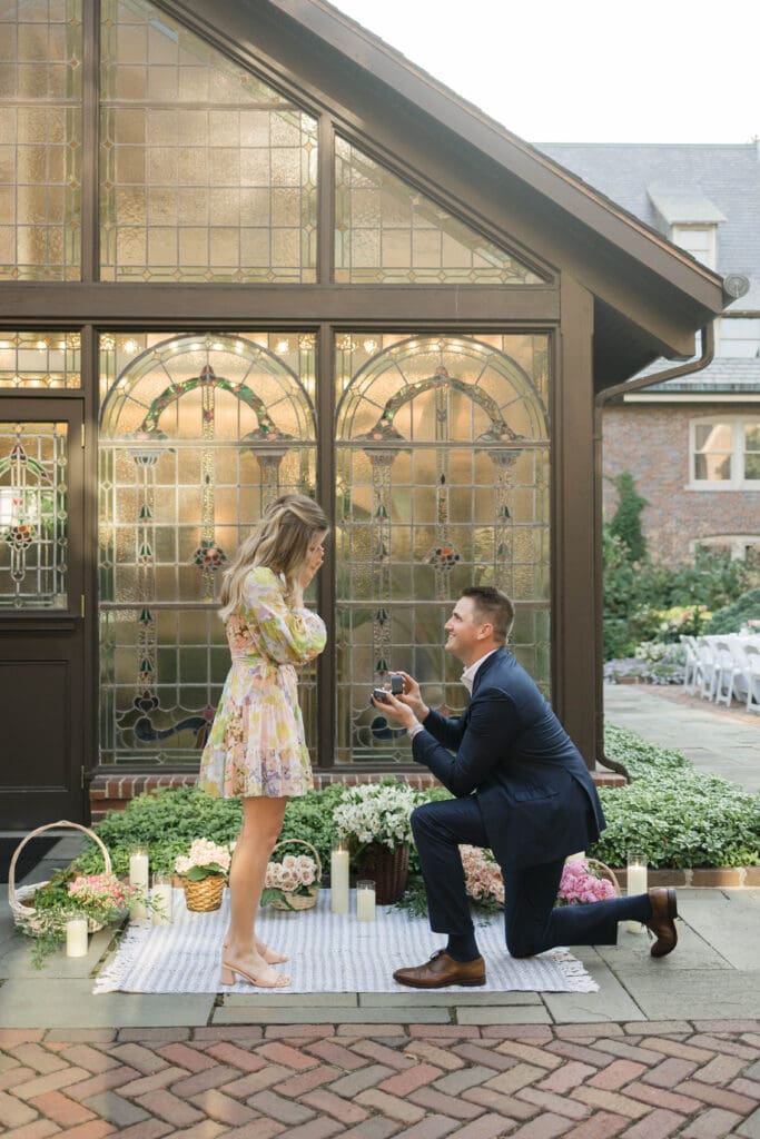 Proposal at The American Club in Kohler with the groom-to-be on one knee during a romantic engagement moment.