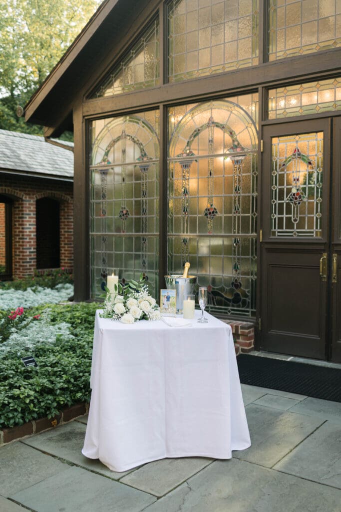 Romantic proposal setup at The American Club with champagne, flowers, and a framed photo of the couple
