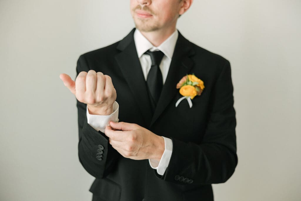 groom adjusting jacket during Santorini wedding morning
