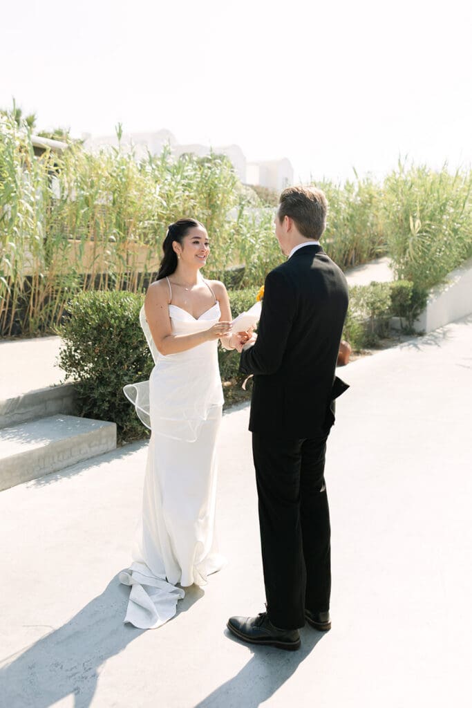 couple holding hands during vows in Santorini