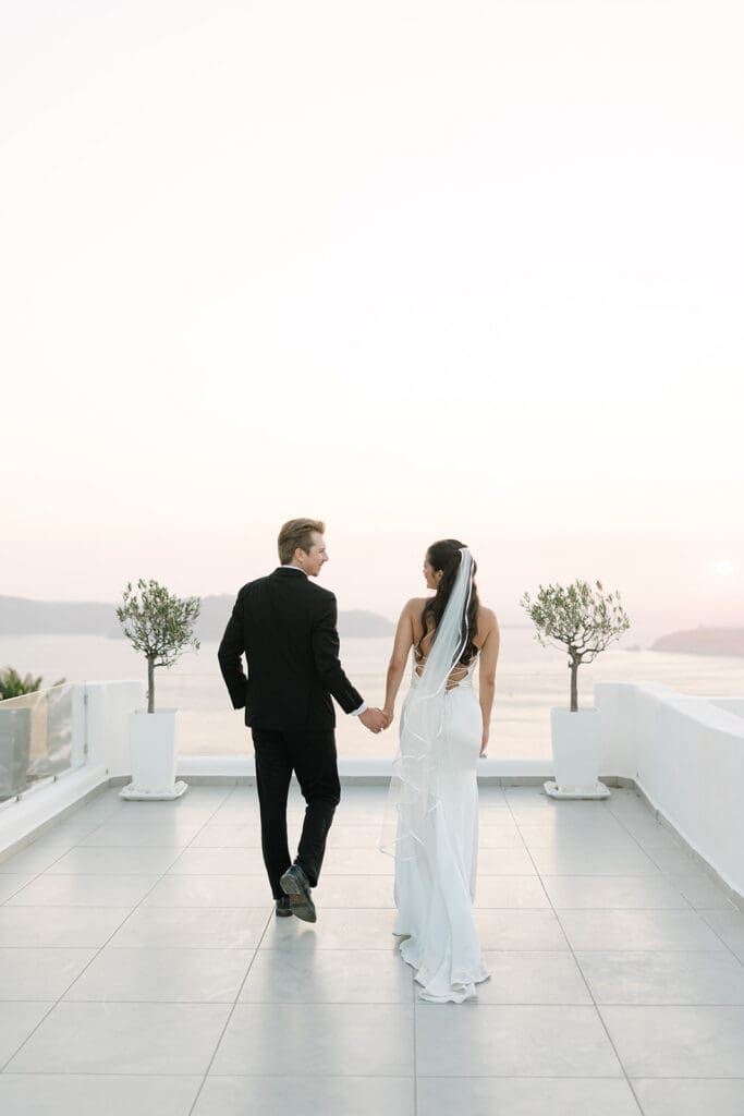 Bride and groom walking towards sunset